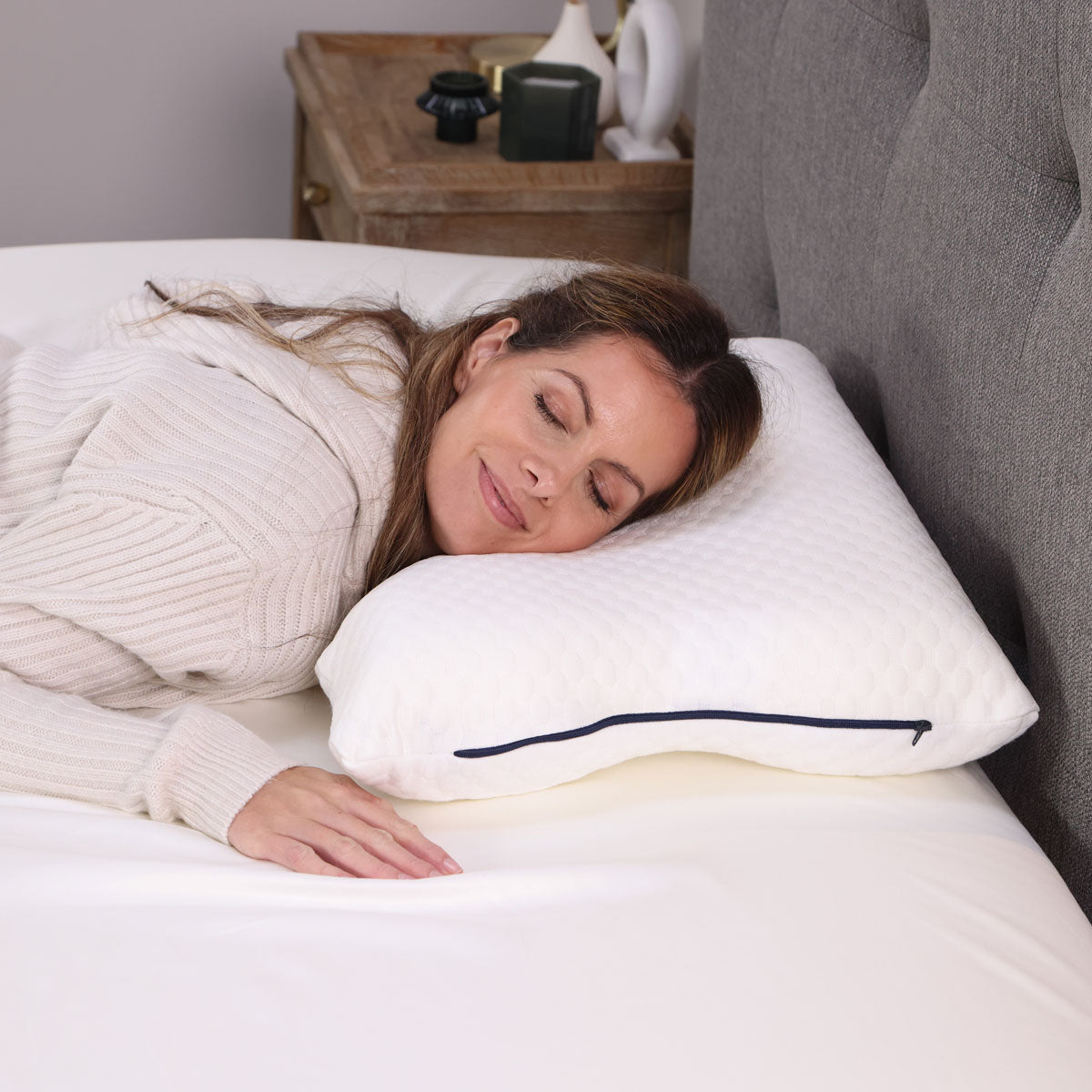 A woman lying on her front on her Seriously Comfortable Ergo pillow 