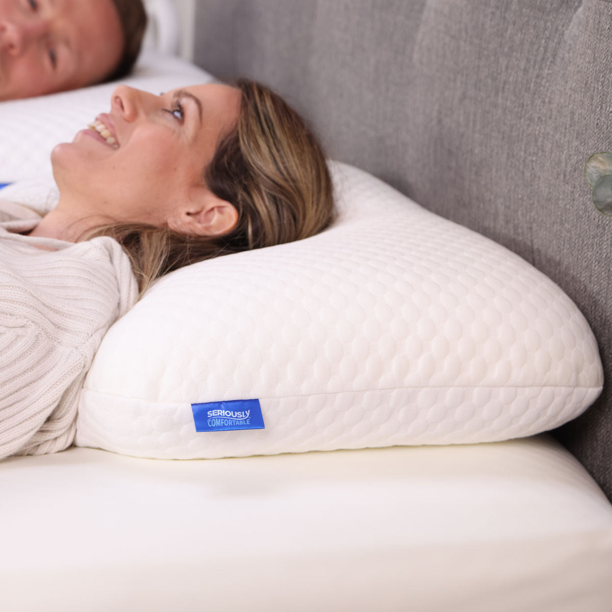 A woman lying on her Seriously Comfortable Cool Memory Comfort pillow