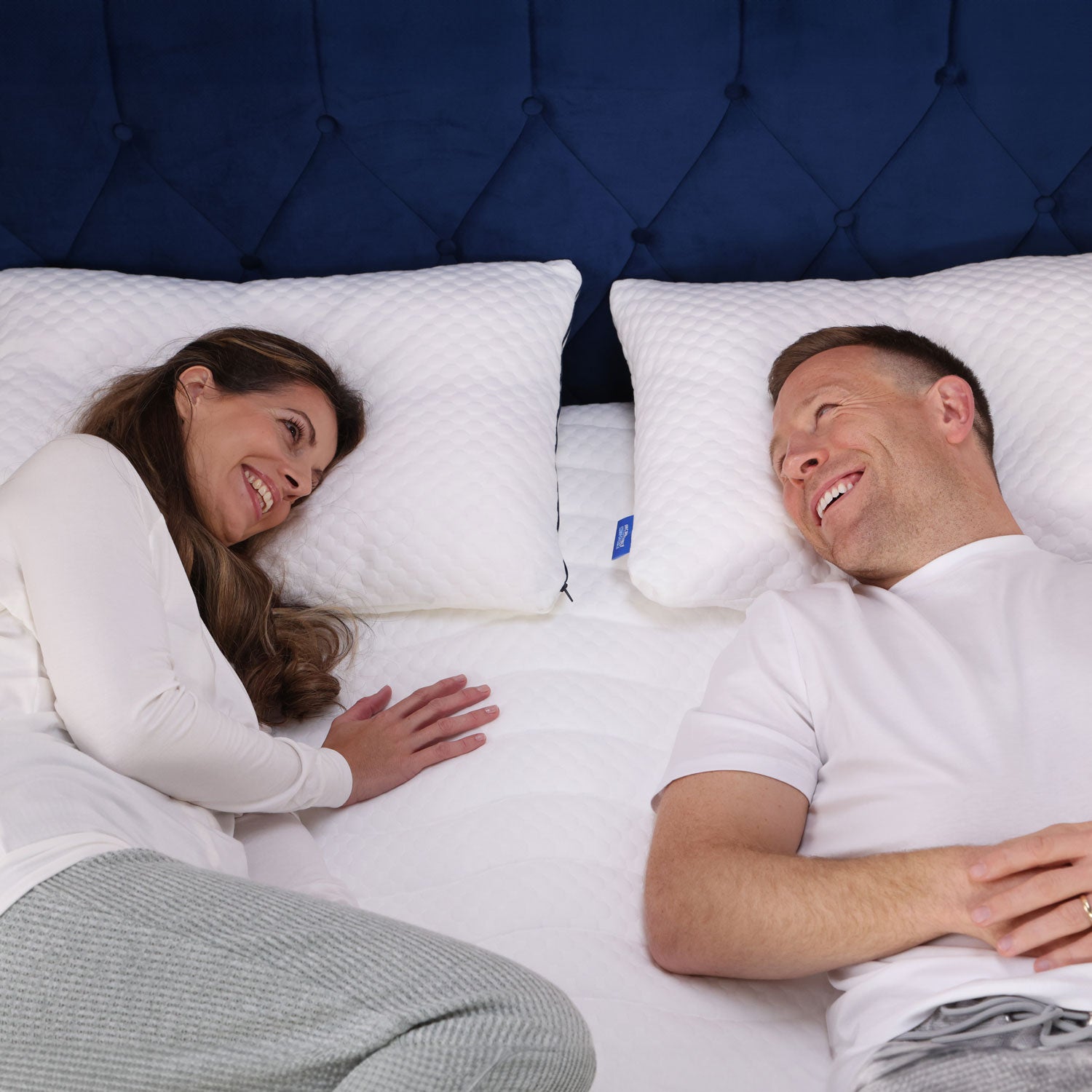 A couple lying on their Seriously Comfortable Cool Revolution mattress topper