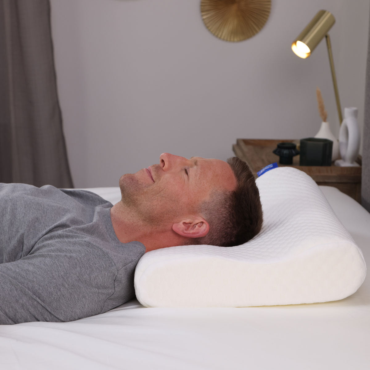 A man lying on his Seriously Comfortable Anatomic Comfort pillow