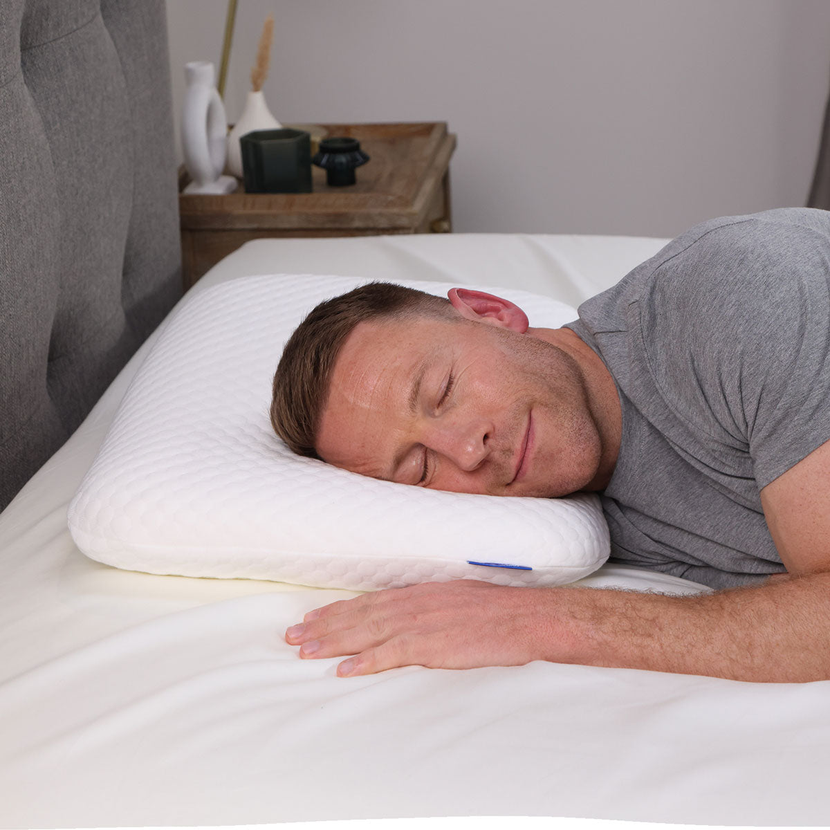 A man lying on his Seriously Comfortable Memory Comfort Compact pillow 