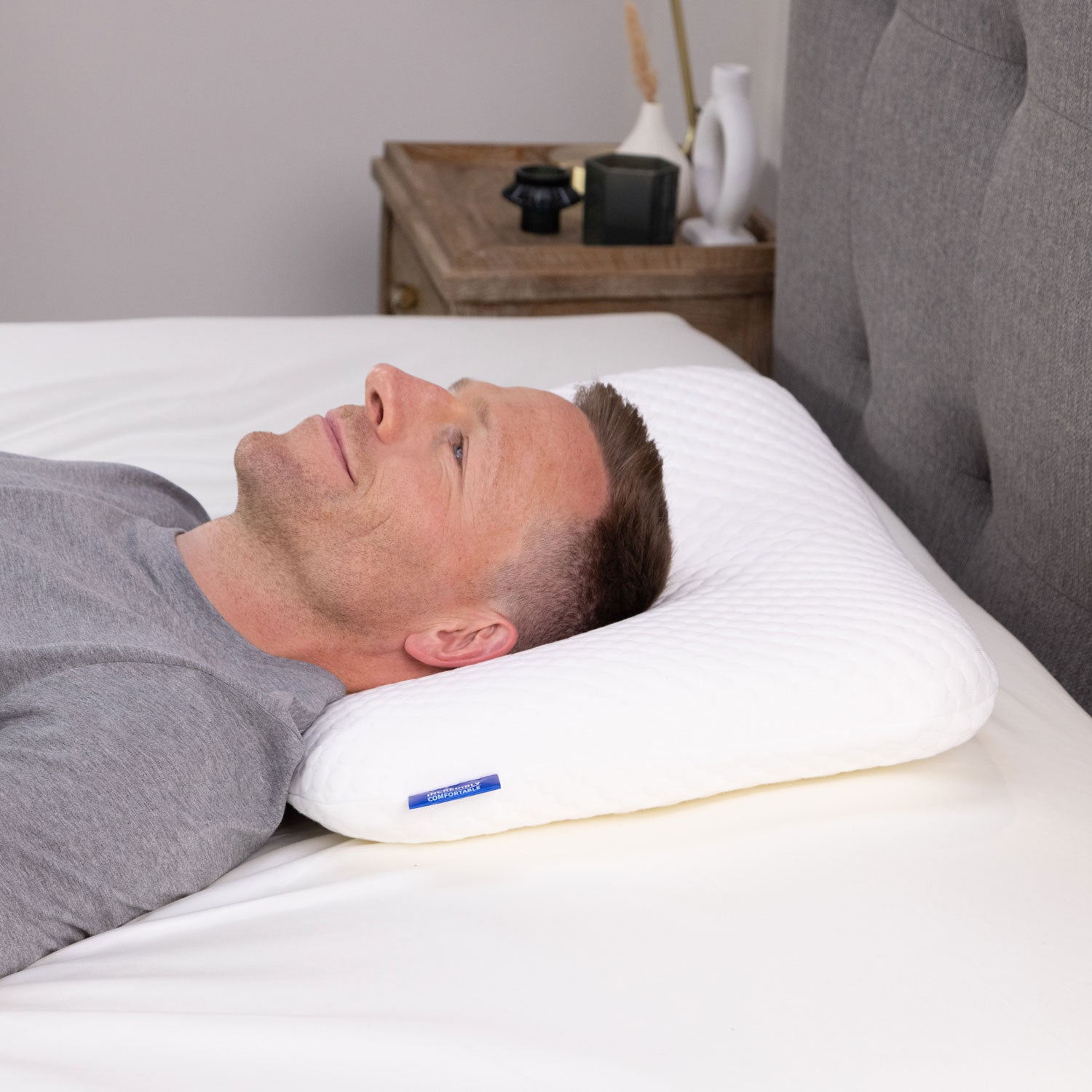 A man lying on his Seriously Comfortable Memory Comfort Compact pillow 